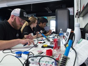From left, Chad Obrigewitsch, Eryn Langdon and Pran Pandey work to create parts for devices known as LipSyncs, which are mouth operated joysticks, at CrashBang Labs on 11th Avenue.