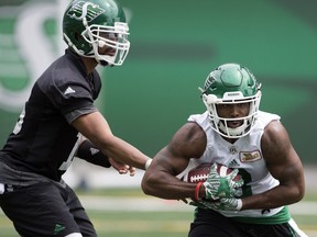 Brandon Bridge hands off to Marcus Thigpen (8) during a recent Riders practice.