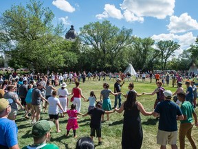 People participate in a round dance together during the Trespassers Powwow at the Justice for our Stolen Children camp across from the Saskatchewan legislative building.