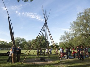 Members of the Wascana Centre Authority and the Provincial Capital Commission work on taking the teepee down at the Justice For Our Stolen Children camp outside the Saskatchewan Legislative Building in Regina.