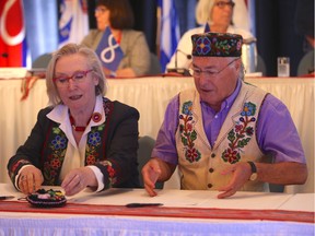 Minister of Crown-Indigenous Relations Carolyn Bennett (left) and Clement Chartier (right) sign the Metis Nation Housing Sub-Accord in Saskatoon's Bessborough Hotel on July 19, 2018.