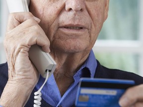 This illustrative photo shows a man relaying personal identification information over the phone.