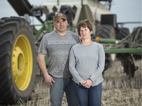 Russell Herold, left, and his wife Raelene stand near their tractor during seeding on the family farm near Montmartre.  Their son Adam was one of the players killed in the Humboldt Broncos bus collision.