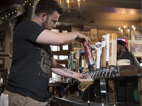 John Christie, day manager at Victoria's Tavern, pours a pint for a customer.