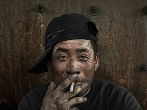 A Chinese labourer takes a break at a steel factory in Inner Mongolia, China. China’s hunger for raw materials has led it to invest in mining companies around the world.