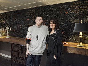 Marie Agioritis and her son Kayle Best stand in front of a blackboard covered in messages to her other son, Kelly Best, who died of a fentanyl overdose. Photo by Heidi Atter.