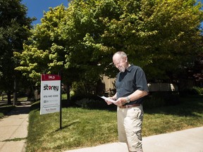 Donald Bergeron poses for a photograph with a personalized letter which he and his family received as part an offer to buy his house in Toronto on Thursday, July 19, 2018. Writing letters in the offer process is becoming a growing common tactic for buyers.