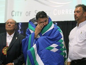 Ron Delorme of the Vancouver Canucks fights to hold back tears as he's presented a blanket from Fred Sasakamoose, left, during a Star Blanket ceremony with the Beardy's First Nation. The blanket was to honour Delorme and his accomplishments.