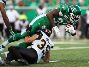 REGINA, SASK : July 5, 2018 -- Saskatchewan Roughriders running back #33 Jerome Messam is brought down by Hamilton Tiger-Cats #35 Mike Daly during a game at Mosaic Stadium. BRANDON HARDER/ Regina Leader-Post