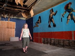 Dorothy Stuart, the owner of the Wonderland arcade on Broad Street, stands in what's left of her longtime business after a fire at the cafe next door resulted in water damage to the arcade's roof and wall. Stuart was lamenting the loss of the art on the damaged wall, as it's made of plaster and cannot be removed.