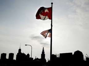 Canadian and American flags fly over the Buffalo skyline.