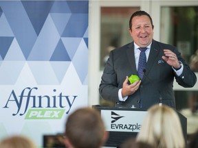 REAL President & CEO Tim Reid accepts an Affinity branded piggy bank in front of the newly named AffinityPlex at Evraz Place.