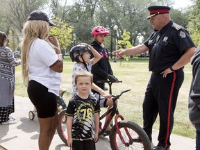Regina Police Service Chief Evan Bray speaks to a family during a barbecue held by emergency services in Victoria Park.