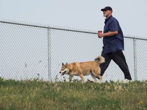 James Stewart walks his dog Kai along the perimeter of the Ross Industrial off-leash dog park on Solomon Crescent.