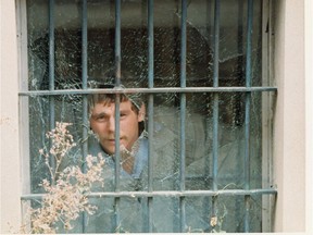 A man looks through a gunshot hole through a window at the Regina Correctional Centre in 1986. An inmate named Brian Schultenkamper planned to escape by having a friend of his shoot him through the window, hoping he would be transported to hospital for treatment. The plan didn't work, as Schultenkamper died from his injuries.