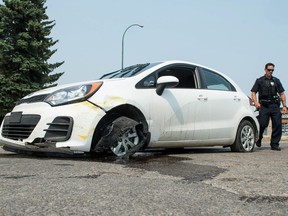 A damaged vehicle with a British Columbia license plate sits at the scene of a police takedown on McAra Street.