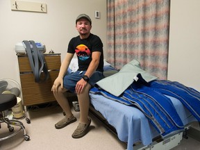 Cory Ringlein, who has primary lymphedema, sits next to a compression pump apparatus in the Therapy Department at Pasqua Hospital. He uses a similar device as part of his treatment for the condition, which causes chronic swelling.