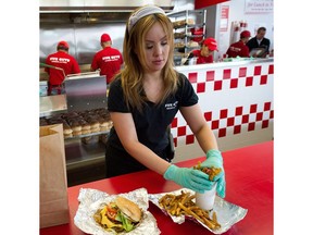 A young woman works the counter at a fast-food restaurant. Saskatchewan's minimum wage goes up a dime come Monday.