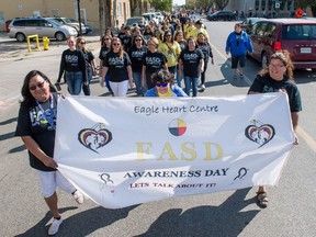 A group of people walk down 12th Avenue to mark International FASD Awareness Day.