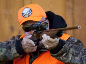 A rifle owner checks the sight of his rifle at a hunting camp property in rural Ontario west of Ottawa on Wednesday Sept. 15, 2010.