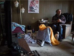 George Moffatt, a 77-year-old man who has been living without heat or power for several months, sits in his home in the Glen Elm Trailer Park. At his heels is his dog Kricket.