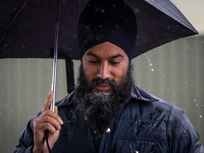 NDP Leader Jagmeet Singh uses an umbrella to shield himself from the rain as he arrives for a visit to the Rumble on Gray Street Fair, in Burnaby, B.C., on Saturday September 15, 2018.