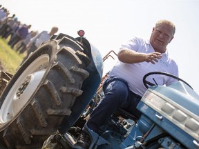 Ontario Premier Doug Ford sits on a Ford tractor as he plows a furrow at the International Plowing Match in Pain Court Ont. Tuesday, September 18, 2018.