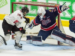 Regina Pats goalie Max Paddock slides across to stop Moose Jaw Warriors forward Cade Hayes during WHL exhibition play at the Brandt Centre on Saturday.