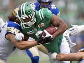 Saskatchewan's Marcus Thigpen lays his shoulder into a Winnipeg Blue Bombers defender.