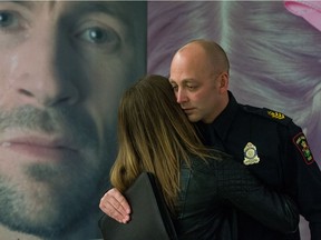 Sgt. Troy Dumont of the Prince Albert Police receives a hug after giving emotional testimony at the launch of SGI's new advertising campaign, designed to stop impaired driving, held at the Saskatchewan Legislative Building. Pictured behind the officer is an actor who appears in the SGI campaign.
