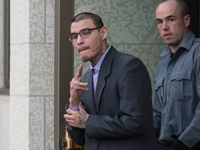 Gregory James Wolfe, left, flashes a gesture at the camera just after being found guilty of first degree murder in the 2016 death of Ryan Sugar at the Court of Queen's Bench on Victoria Avenue.