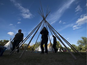 Members of the Justice for Our Stolen Children Camp take down a teepee in Wascana Centre in Regina on Tuesday.