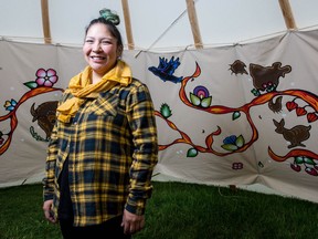 Larissa Kitchemonia stands with the teepee liner she painted as part of the kêhtê-ayak art installation that is currently being shown at First Nations University of Canada.