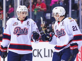 Jake Leschyshyn #19 of the Regina Pats celebrates with Nick Henry after scoring against the Calgary Hitmen during a WHL game at the Scotiabank Saddledome on Sunday.