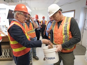 Federal Minister of International Trade Diversification Jim Carr, left, listens to Viterra facility manager Joe Wilke explain the process for testing flax seed that is being dropped off at the Viterra grain terminal near Balgonie on Friday.