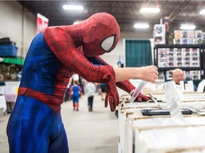 Adam Skoretz, dressed as Spiderman, digs through comic books during Regina Fan Expo, held at Evraz Place. "I'm trying to find the good stuff," he said.