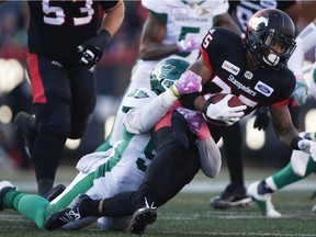 The Saskatchewan Roughriders' Chad Geter, left, brings down Calgary Stampeders running back Don Jackson, during Saturday's CFL game at McMahon Stadium. Geter had two tackles for a loss while starting in place of Charleston Hughes.