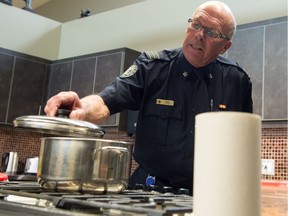 REGINA, SASK : October 9, 2018  -- Randy Ryba, Regina's fire marshall, demonstrates the correct way to place a lid on to a pot in the event that the pot's contents were to catch fire. Such an action, done after turning off the stove's heat source, should extinguish the fire, he said, speaking to media about the dangers of cooking fires at an event held at No. 4 Fire Station on Dewdney Avenue to mark Fire Prevention Week in Regina. If such actions are not effective and the fire continues, he noted, homeowners should call the fire department. BRANDON HARDER/ Regina Leader-Post