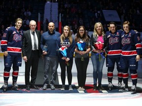 Regina Pats athletic therapist Greg Mayer, 
third from left, is shown with his family Sunday during a pre-game ceremony that recognized his 1,500th WHL game.