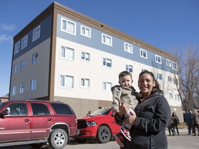 Danelle Nighttraveller and her daughter Iris stand outside their new  affordable rental housing in Regina.