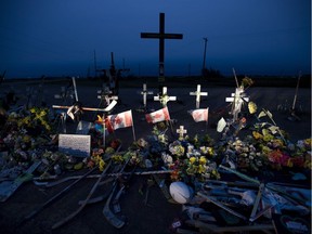 A memorial made of hockey sticks, crosses and Canadian flags is seen at the crash site of the Humboldt Broncos hockey team near Tisdale, Sask.