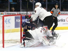 Dalton Hamaliuk of the Moose Jaw Warriors tries to knock Koby Morrisseau of the Regina Pats out of the crease as goalie Adam Evanoff makes a save in WHL action at the Brandt Centre on Saturday.