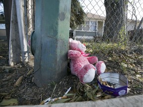 A teddy bear sits out front of a home on the 900 block of Cameron Street where a 16-year-old girl was killed.