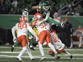 Saskatchewan Roughriders quarterback Brandon Bridge tries to leap over B.C. Lions linebacker Jordan Herdman at Mosaic Stadium, where the Green and White clinched a home playoff game on Saturday.