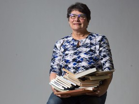 Author Alison Lohans holds copies of the books she has had published since 1983.