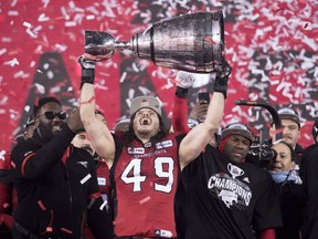 Calgary Stampeders linebacker Alex Singleton hoists the Grey Cup after defeating the Ottawa Redblacks at the 106th Grey Cup in Edmonton, Alta. Sunday, Nov. 25, 2018.