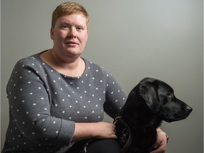 Ashley Nemeth kneels next to her new guide dog, Danson, at the CNIB office on Broad Street.