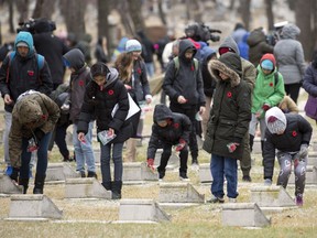 Regina Public School children from several local schools place a poppy on military headstones in Canadian fields of honour during the No Stone Left Alone Remembrance Day ceremony held at the Regina Cemetery.