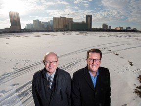 Regina Mayor Michael Fougere, right, and Saskatchewan's Minister of Government Relations Warren Kaeding stand with their backs to the undeveloped former CP Rail yard along Dewdney Avenue.