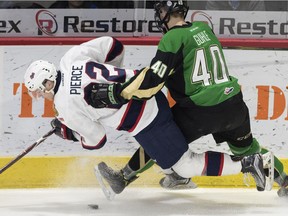 The Regina Pats' Duncan Pierce and the Prince Albert Raiders' Kaiden Guile get tangled up heading into the boards during a game last season at the Brandt Centre.